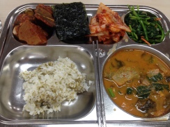 Top left is a fish and potato stew that's very savoury and rich and lovely. Nori for wrapping around rice. Kimchi and spinach namul. Rice. Kimchi liquid/soybean paste based soup with greens and tofu and onion.